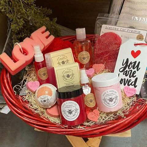 Gift basket with various products including candles, soap, and a car freshener.